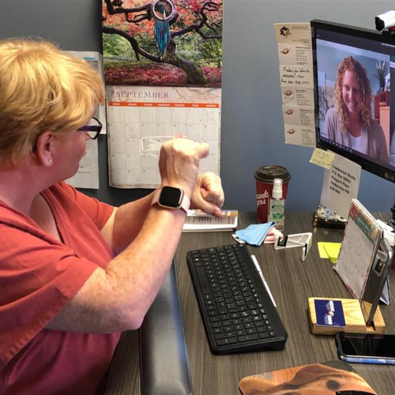 Personne travaillant sur un ordinateur en utilisant la langue des signes / A person working on a computer using sign language